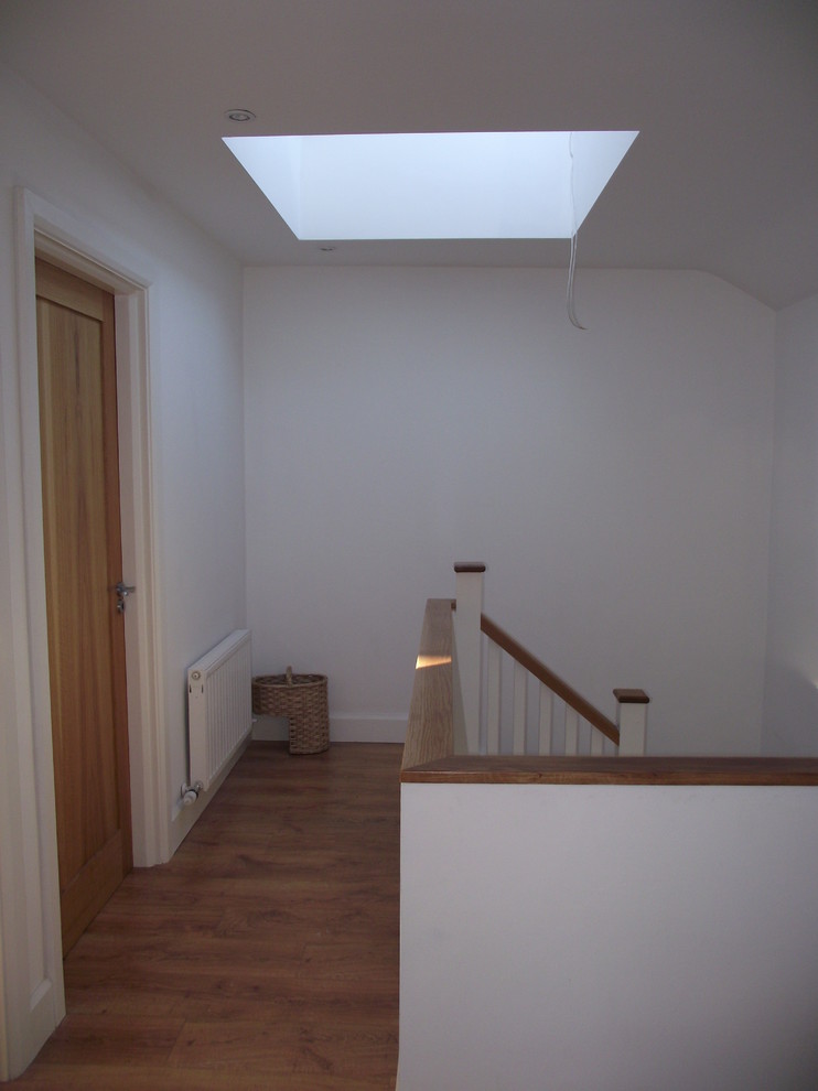 Aménagement d'un couloir moderne de taille moyenne avec un mur blanc et parquet clair.