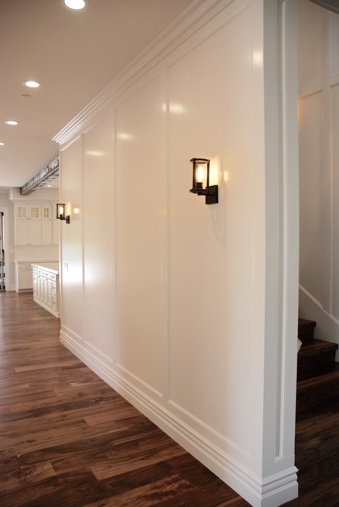 Ejemplo de recibidores y pasillos tradicionales extra grandes con paredes blancas, suelo de madera en tonos medios y suelo marrón