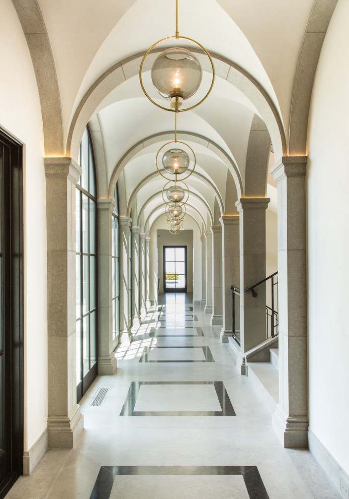 Ispirazione per un grande ingresso o corridoio mediterraneo con pareti bianche, pavimento in marmo e pavimento multicolore