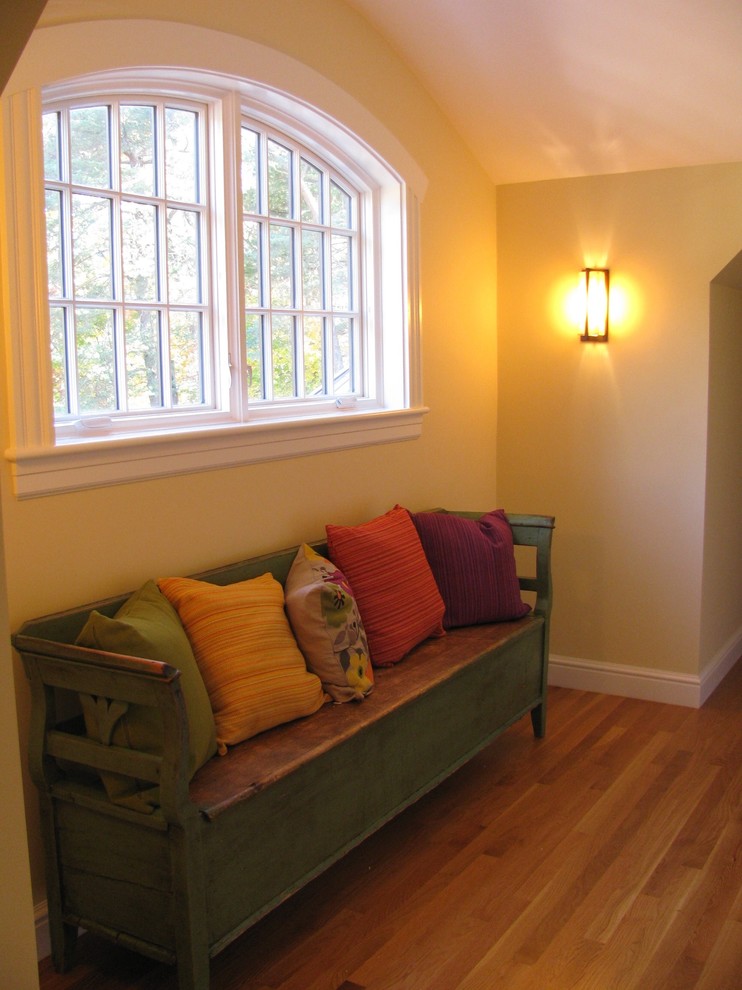 Cette image montre un couloir traditionnel de taille moyenne avec un mur jaune, un sol en bois brun et un sol marron.