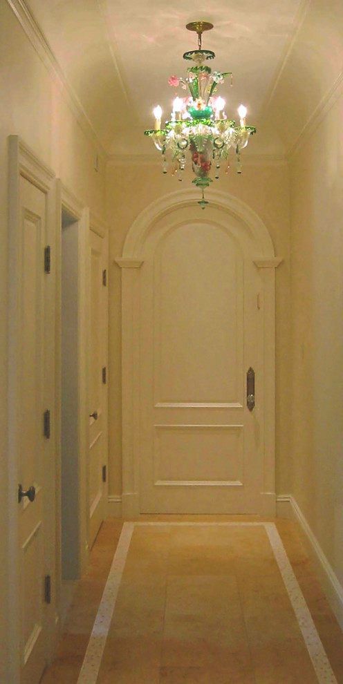 Klassisk inredning av en mellanstor hall, med beige väggar, kalkstensgolv och beiget golv