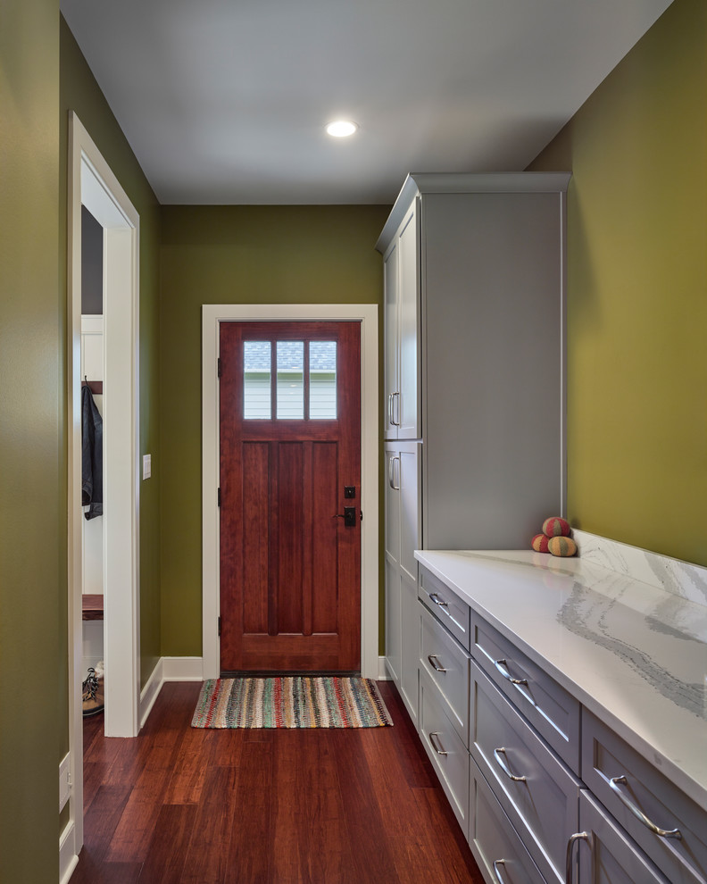 Réalisation d'un couloir craftsman de taille moyenne avec un mur vert, parquet foncé et un sol marron.