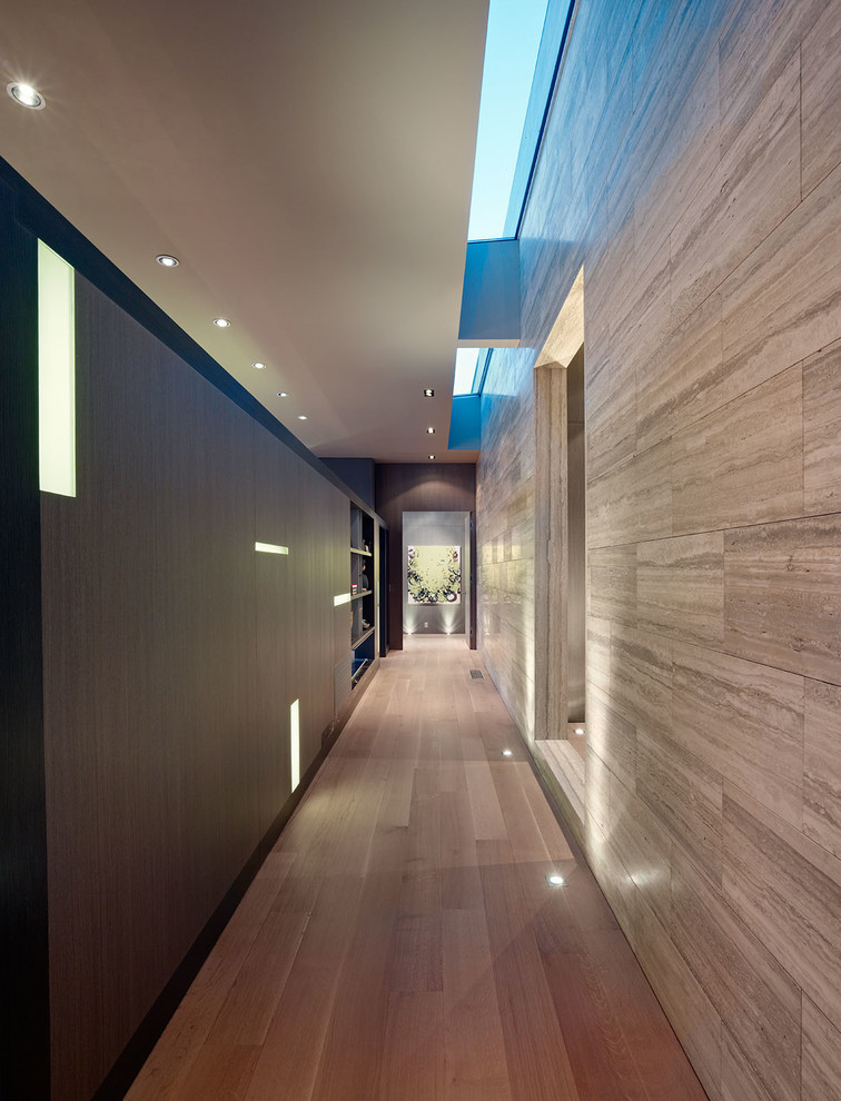 Idée de décoration pour un grand couloir design avec un mur beige et parquet clair.