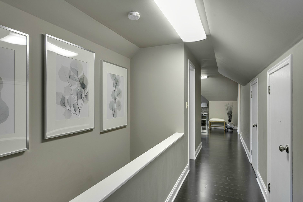 Cette image montre un couloir design de taille moyenne avec un mur gris et parquet foncé.