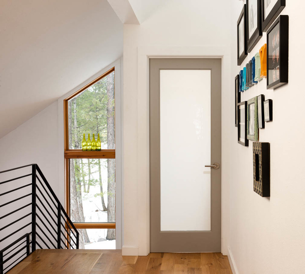 Ispirazione per un piccolo ingresso o corridoio minimal con pareti bianche, pavimento in legno massello medio e pavimento marrone