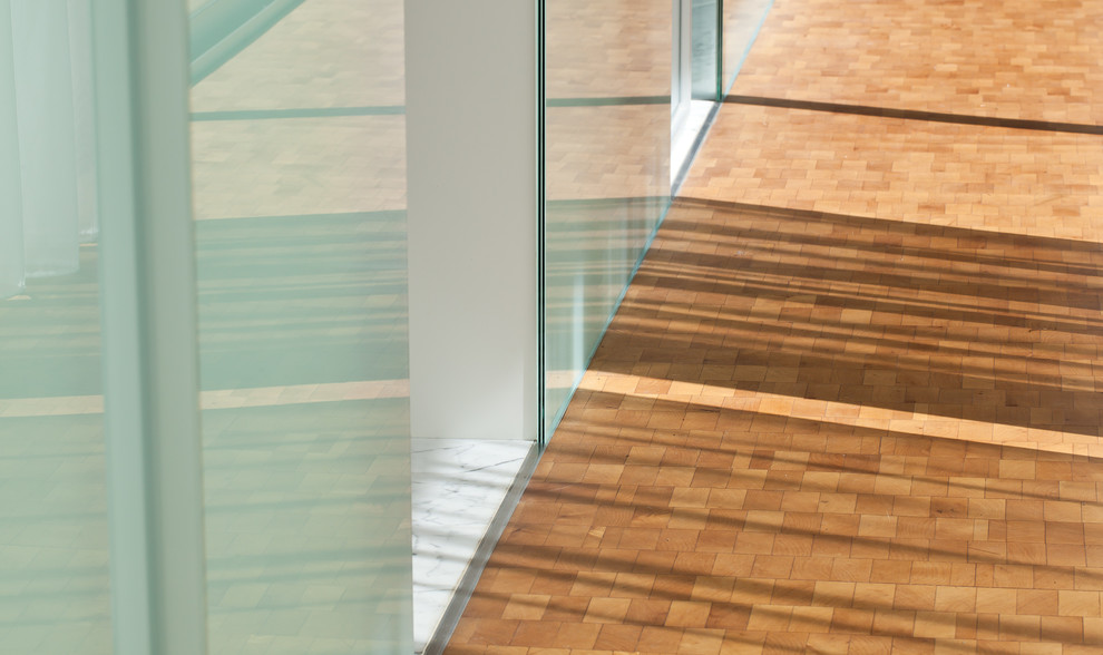 Immagine di un ingresso o corridoio minimalista di medie dimensioni con pavimento in legno massello medio