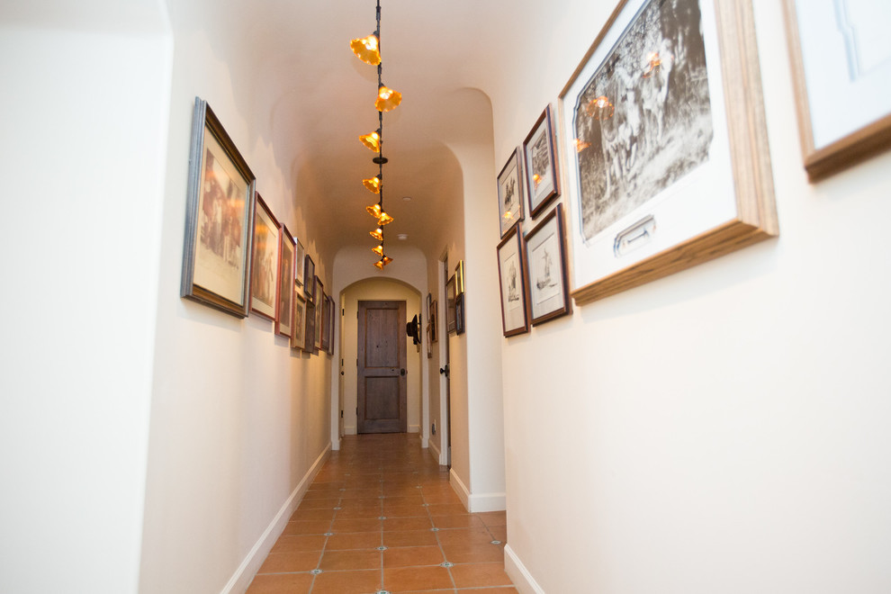 Idee per un grande ingresso o corridoio stile americano con pavimento in terracotta, pavimento arancione e pareti beige