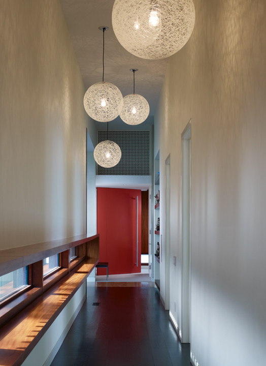Cette image montre un couloir minimaliste de taille moyenne avec un mur blanc.