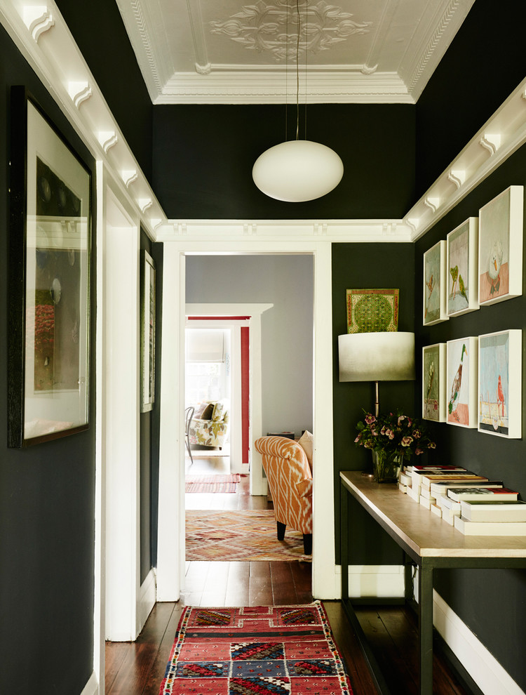Foto de recibidores y pasillos bohemios de tamaño medio con paredes negras y suelo de madera en tonos medios