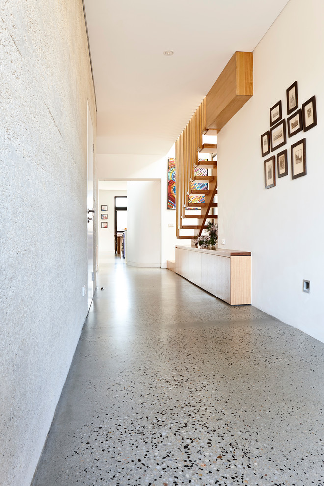 Diseño de recibidores y pasillos contemporáneos de tamaño medio con paredes blancas y suelo de cemento