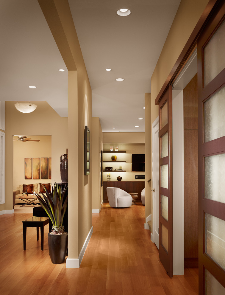 На фото: коридор среднего размера: освещение в современном стиле с бежевыми стенами, паркетным полом среднего тона и коричневым полом