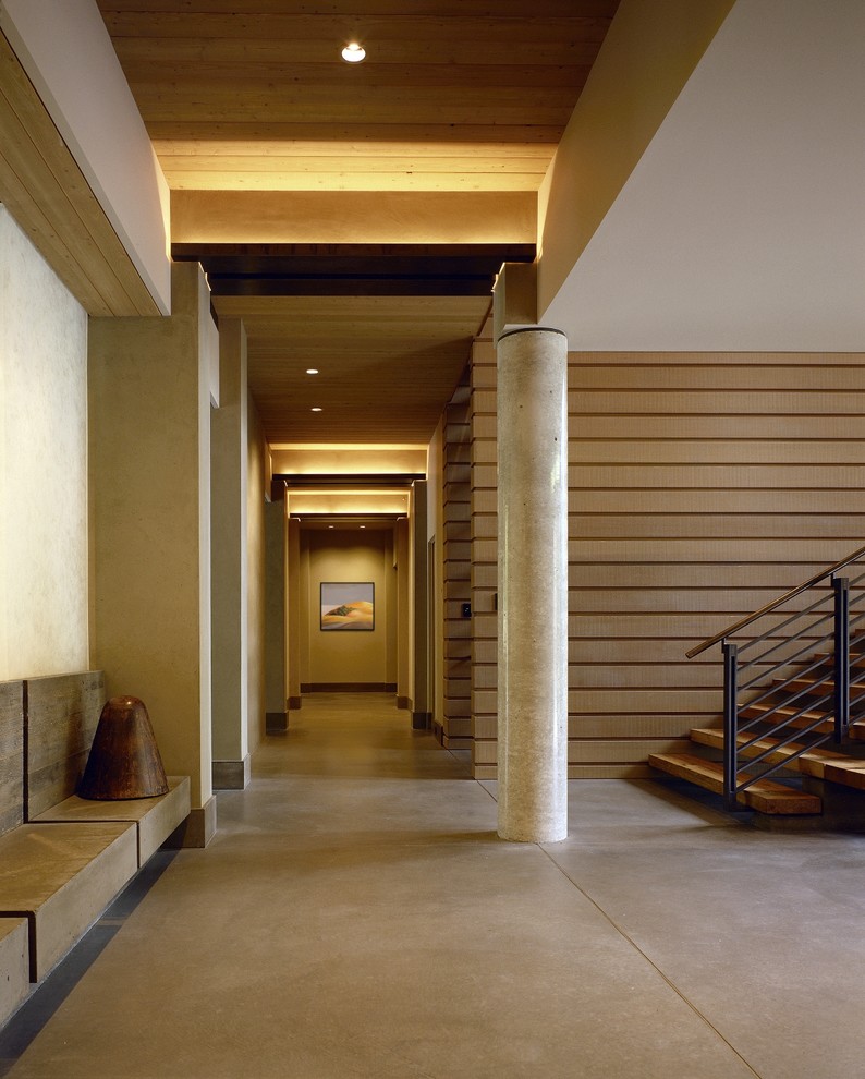 Esempio di un grande ingresso o corridoio minimal con pareti beige e pavimento in cemento