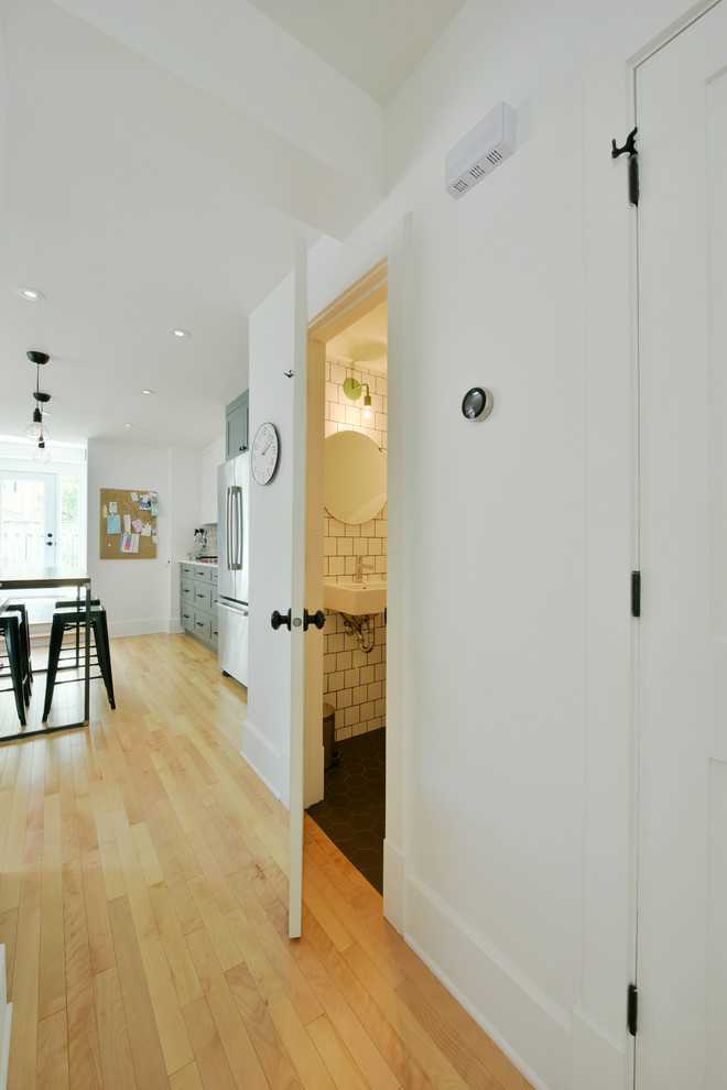 Hallway - mid-sized transitional light wood floor hallway idea in Ottawa with white walls
