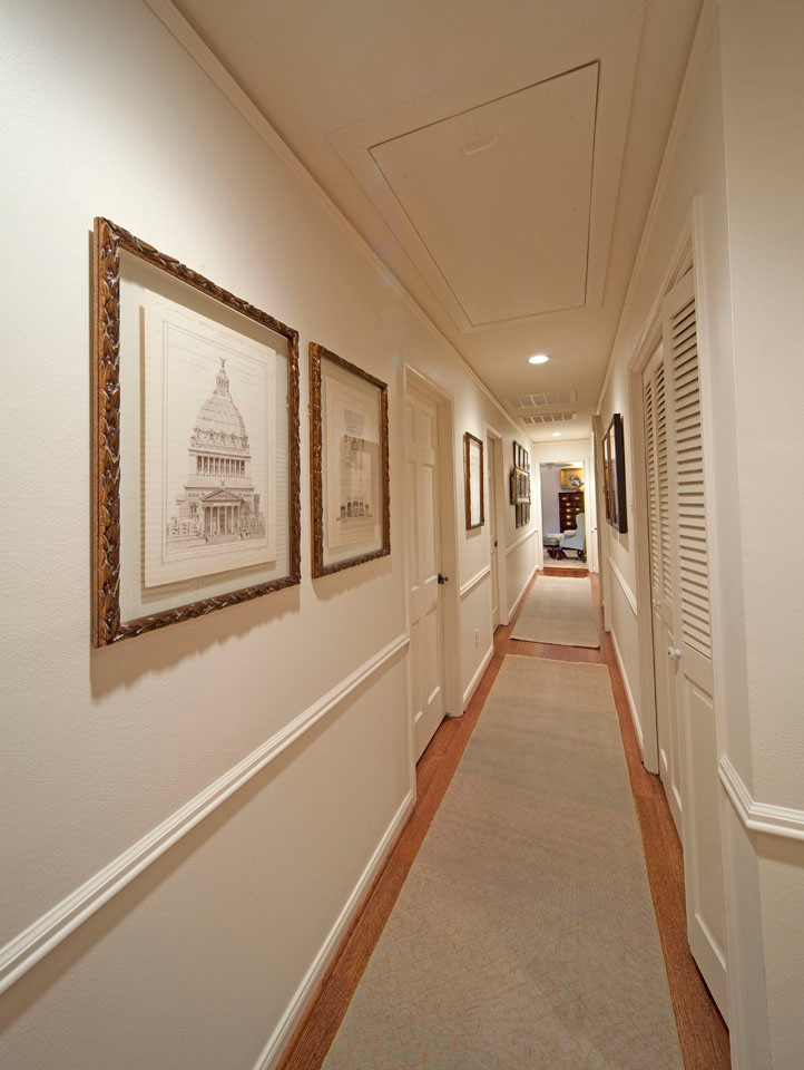 Example of a large tuscan light wood floor hallway design in Houston with beige walls