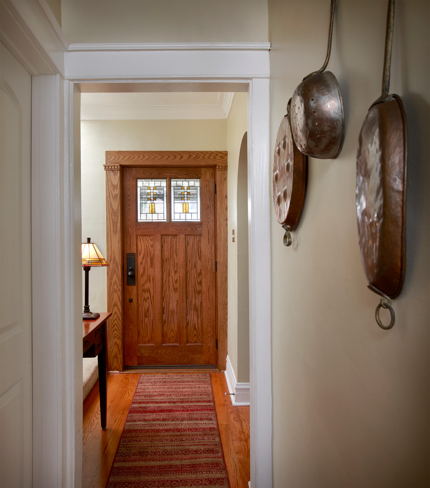 Aménagement d'un couloir craftsman de taille moyenne avec un mur vert et un sol en bois brun.