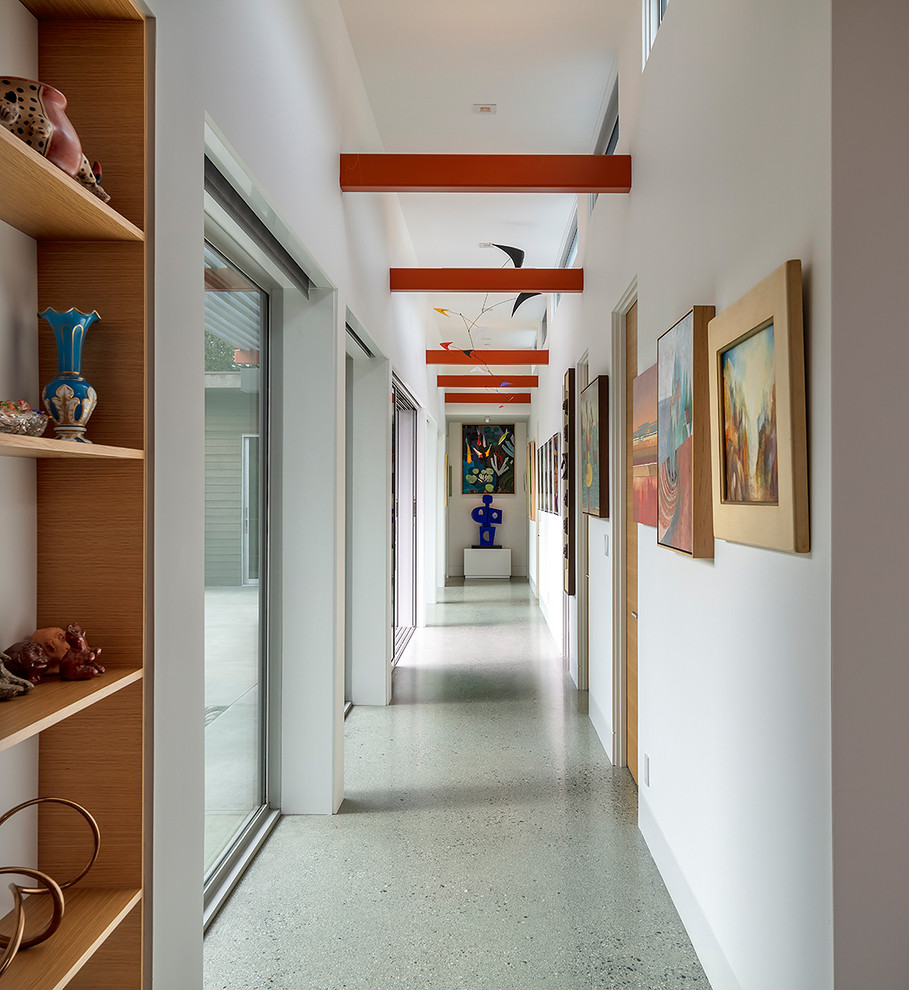 Foto di un ingresso o corridoio minimalista con pareti bianche, pavimento grigio e travi a vista