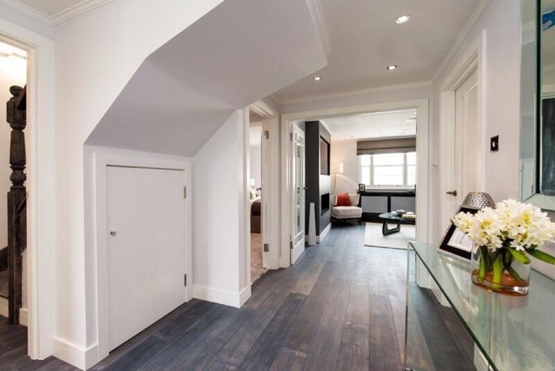 Example of a mid-sized cottage chic dark wood floor hallway design in London with white walls