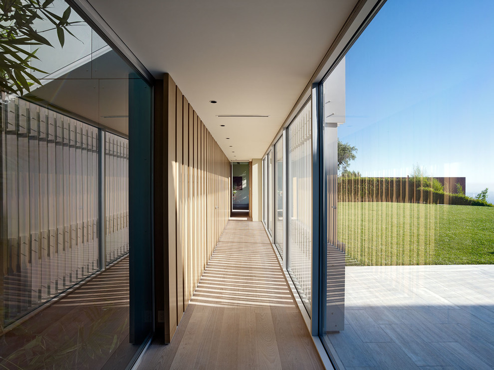 Стильный дизайн: коридор в современном стиле с бежевыми стенами, светлым паркетным полом и коричневым полом - последний тренд