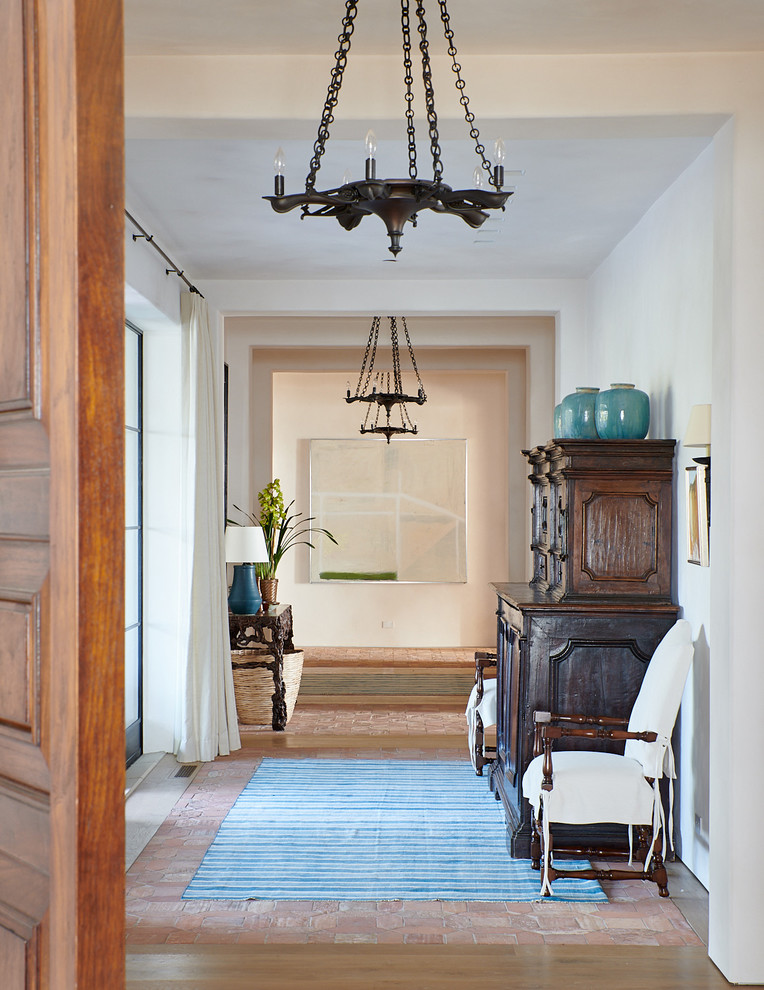 Hallway - mediterranean medium tone wood floor and brown floor hallway idea in Santa Barbara with white walls