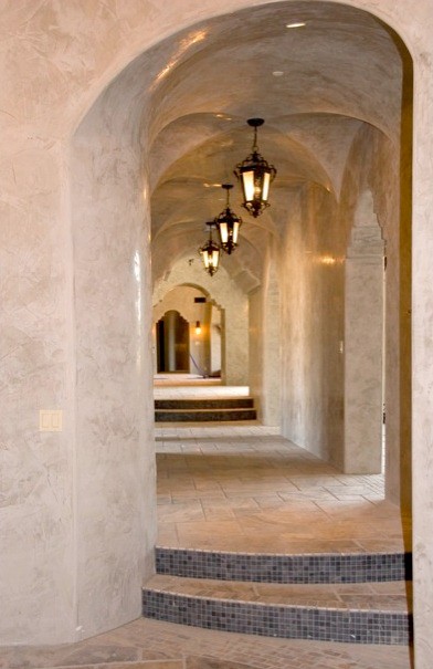 Réalisation d'un grand couloir avec un mur beige et un sol en travertin.