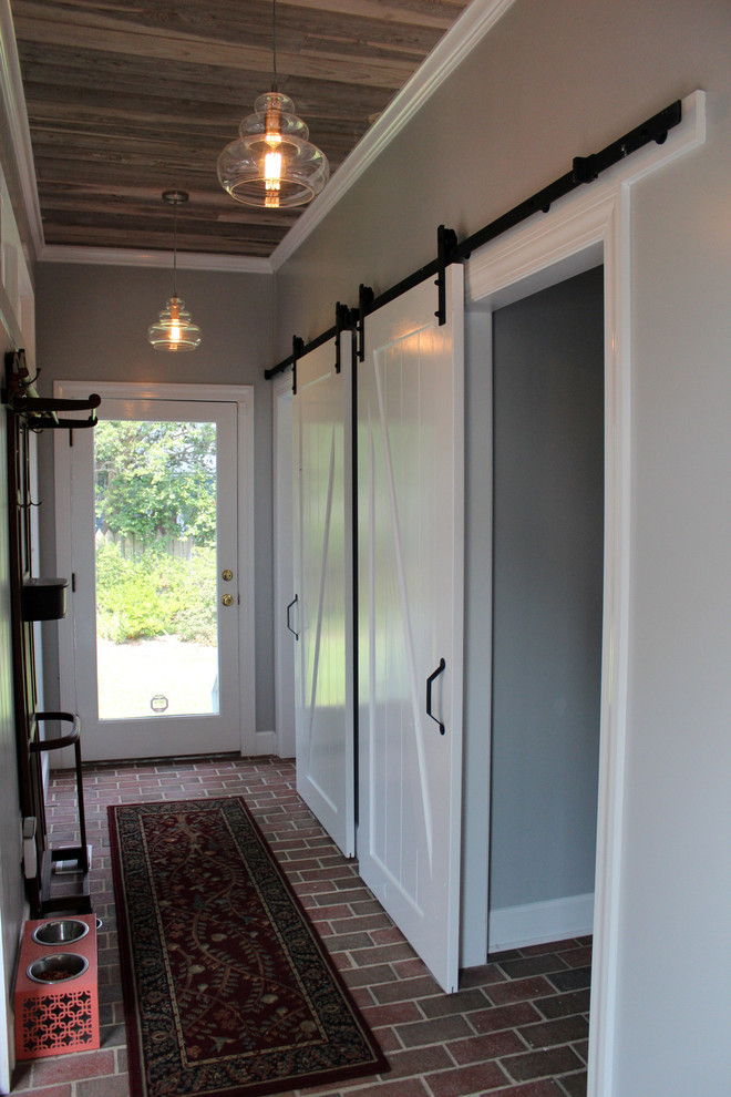 На фото: коридор среднего размера в стиле рустика с зелеными стенами и кирпичным полом с