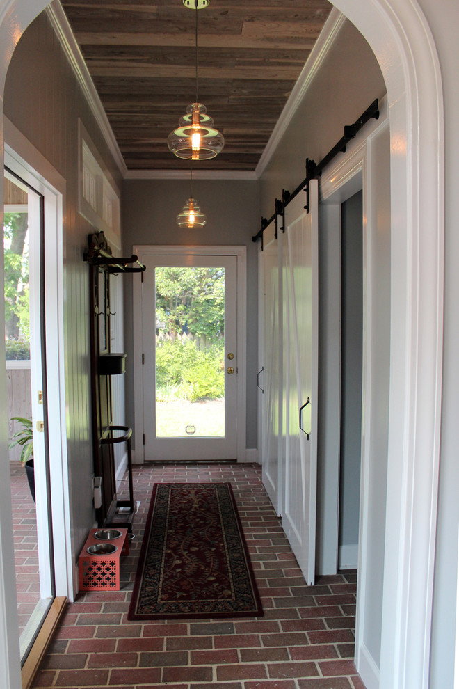 Ispirazione per un ingresso o corridoio stile shabby di medie dimensioni con pareti grigie e pavimento in mattoni
