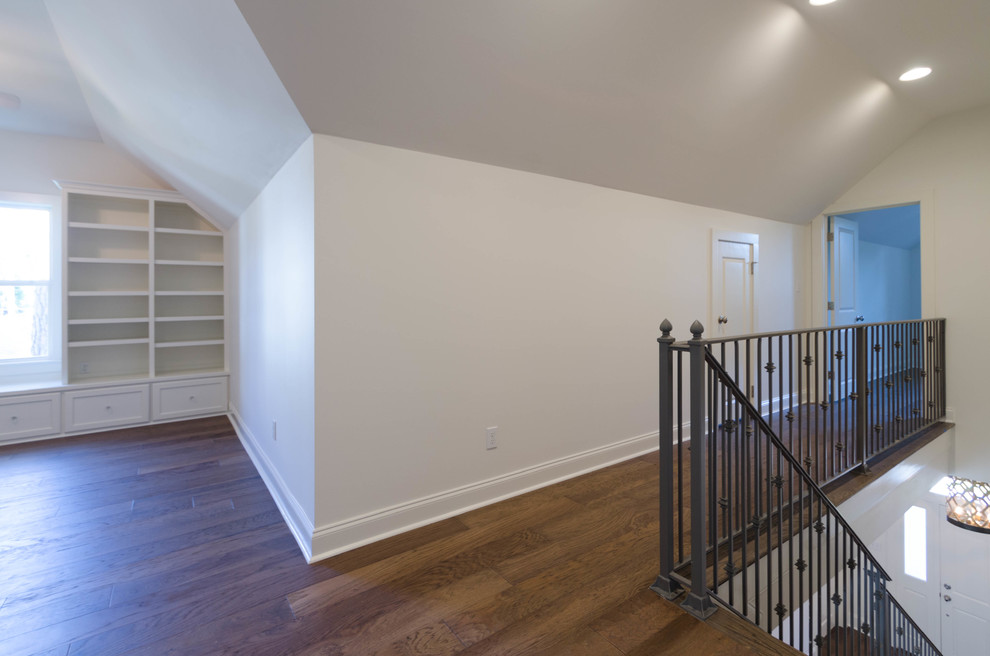 Example of a large classic medium tone wood floor hallway design in New Orleans with white walls