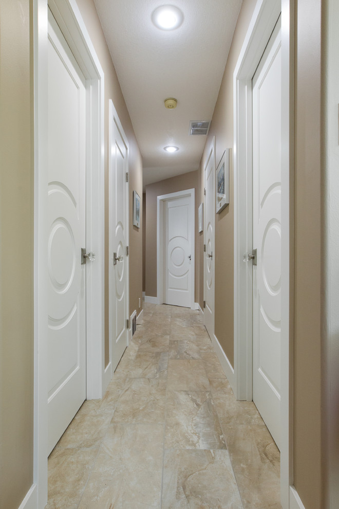 Стильный дизайн: большой коридор в классическом стиле с полом из травертина, коричневыми стенами и бежевым полом - последний тренд