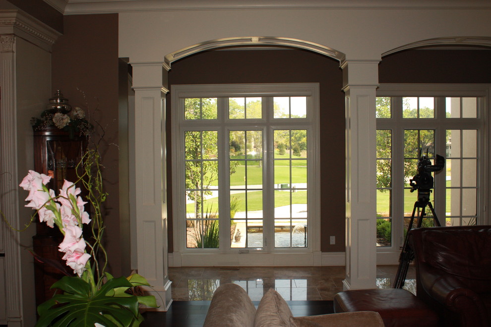 На фото: коридор среднего размера в классическом стиле с коричневыми стенами и полом из керамогранита с