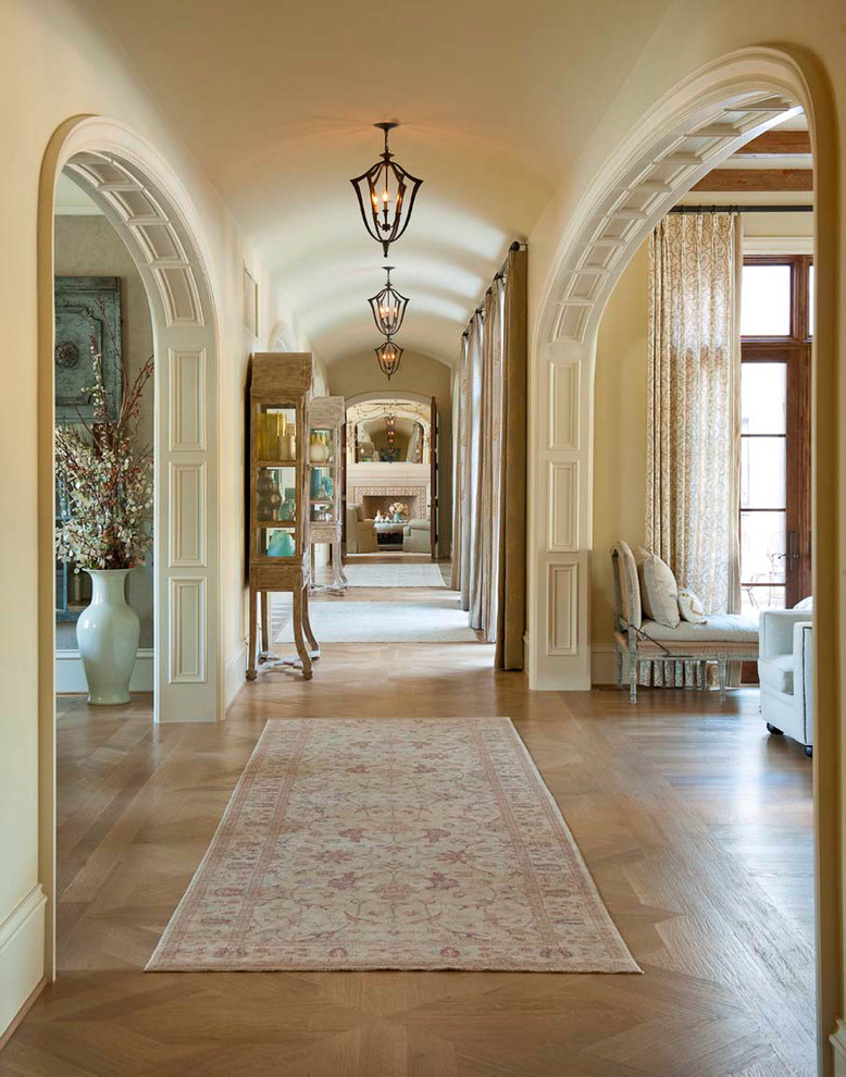 Idée de décoration pour un couloir tradition avec un mur beige, un sol en bois brun et un sol beige.