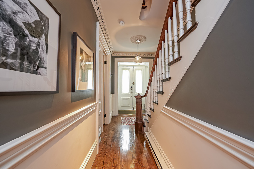 Ispirazione per un ingresso o corridoio classico di medie dimensioni con pareti grigie, pavimento in legno massello medio e pavimento marrone