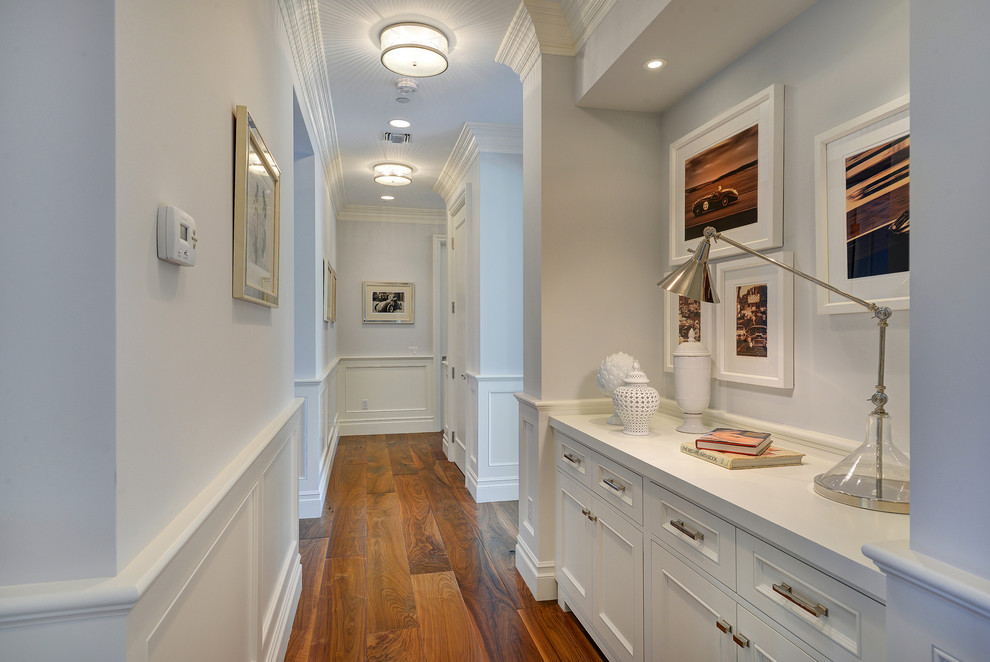 Immagine di un ingresso o corridoio chic con pareti bianche e pavimento in legno massello medio
