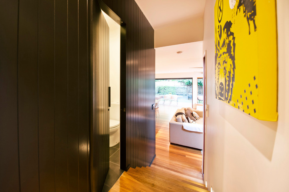 Moderner Flur mit schwarzer Wandfarbe und hellem Holzboden in Brisbane