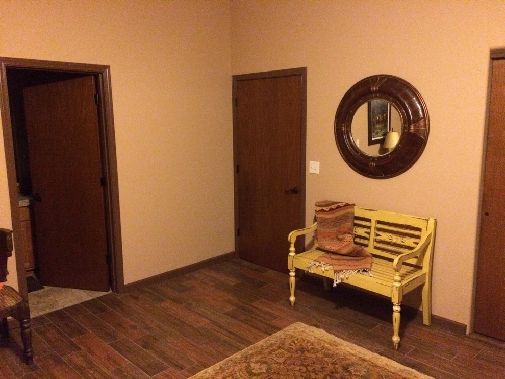 Idée de décoration pour un grand couloir chalet avec un mur beige et un sol en bois brun.