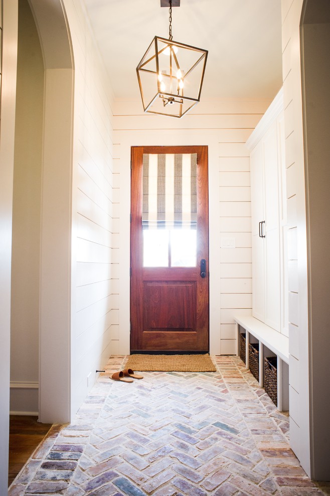 На фото: коридор среднего размера в классическом стиле с белыми стенами, кирпичным полом и разноцветным полом