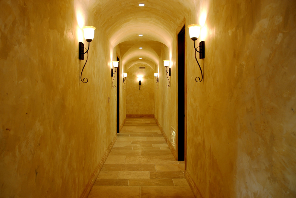 Huge tuscan limestone floor and beige floor hallway photo in Los Angeles with beige walls