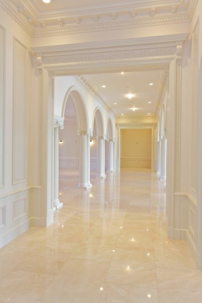 マイアミにある広いトラディショナルスタイルのおしゃれな廊下 (白い壁、大理石の床、ベージュの床) の写真