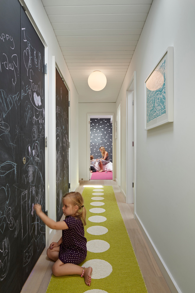 Foto di un ingresso o corridoio minimalista con pareti bianche e pavimento in legno massello medio