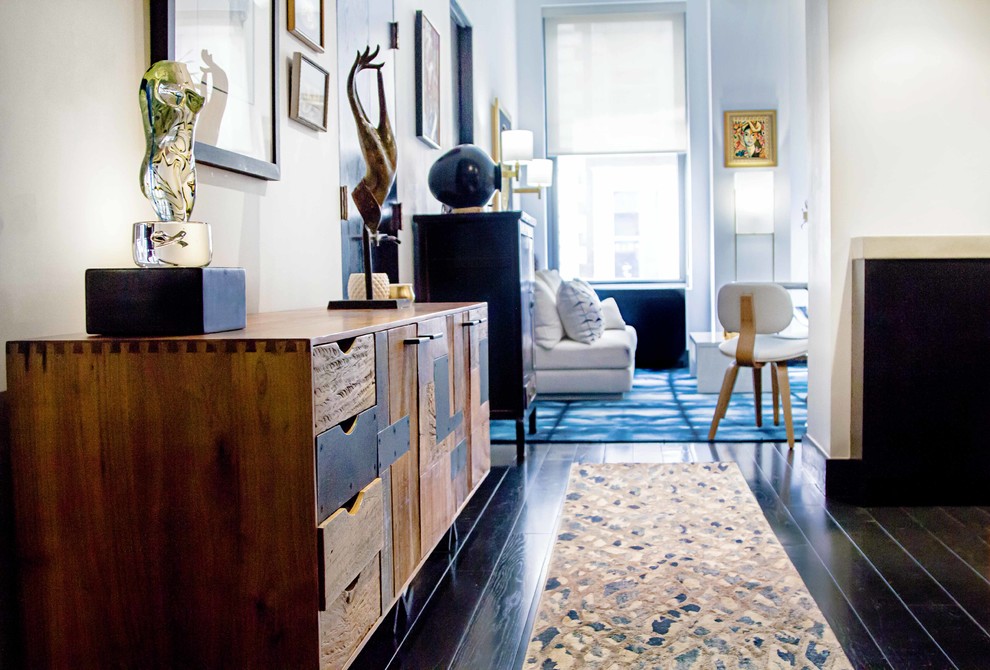 Example of a small trendy painted wood floor and black floor hallway design in New York with white walls