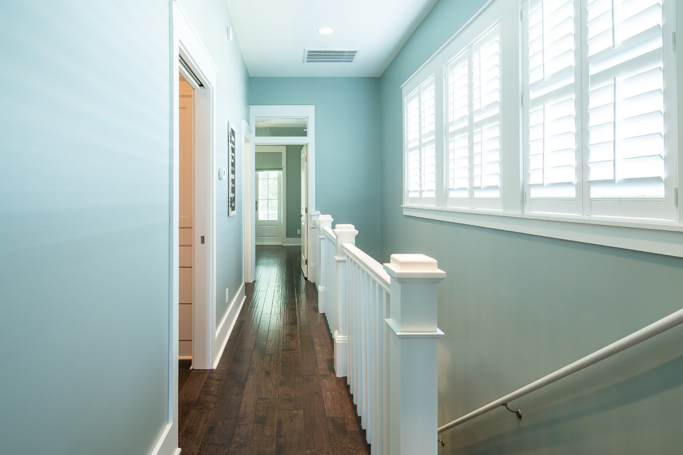 На фото: коридор среднего размера в стиле неоклассика (современная классика) с синими стенами и темным паркетным полом