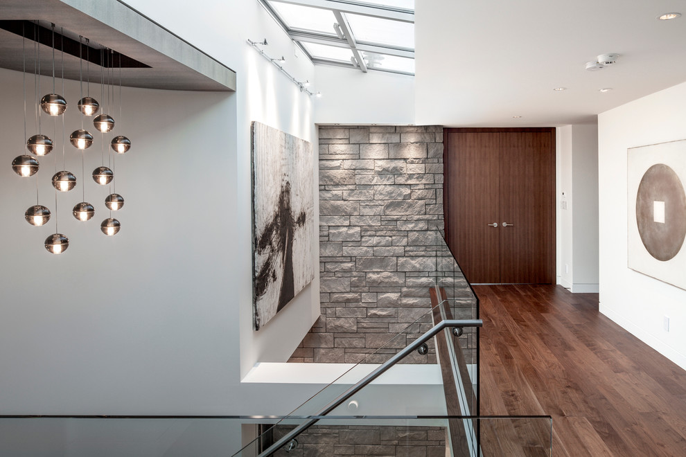 Moderner Flur mit weißer Wandfarbe und braunem Holzboden in Vancouver