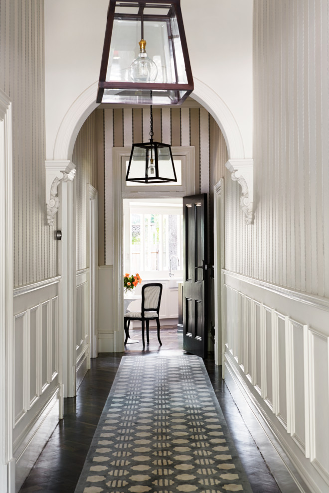 Ispirazione per un ingresso o corridoio chic di medie dimensioni con pareti bianche, parquet scuro e pavimento nero