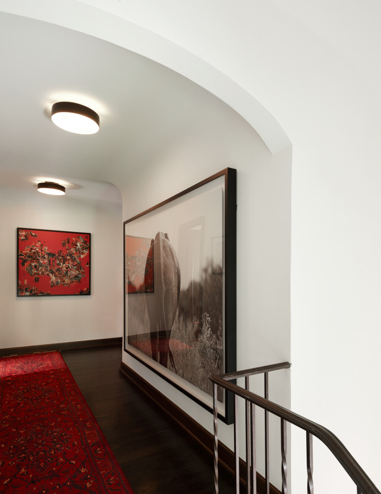 Large eclectic dark wood floor, brown floor and vaulted ceiling hallway photo in Seattle with white walls