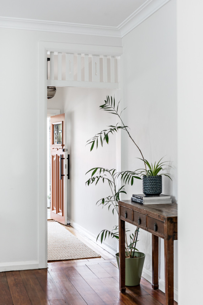 Immagine di un piccolo ingresso o corridoio contemporaneo con pareti bianche, pavimento in legno massello medio e pavimento marrone