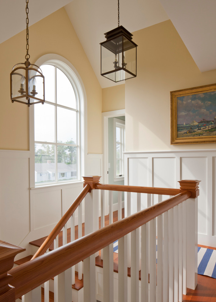 Example of a mid-sized beach style medium tone wood floor and brown floor hallway design in Boston with yellow walls