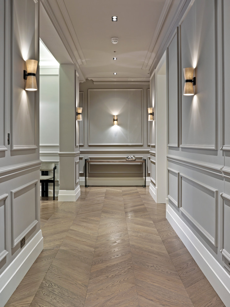 Foto de recibidores y pasillos tradicionales renovados de tamaño medio con paredes grises y suelo de madera en tonos medios