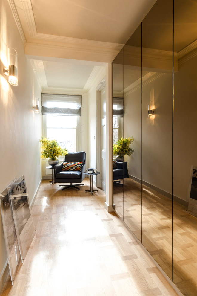 Cette photo montre un couloir chic de taille moyenne avec un mur gris, parquet clair et un sol beige.