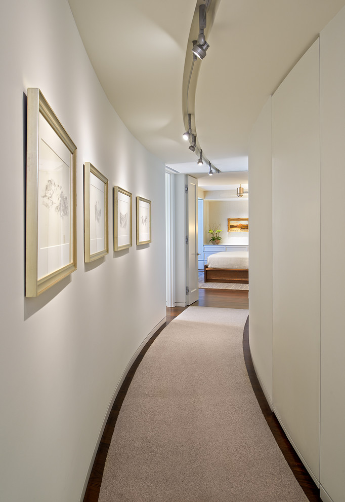 Inspiration pour un couloir design de taille moyenne avec un mur beige et moquette.