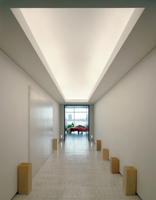 Bild på en mellanstor funkis hall, med vita väggar, ljust trägolv och beiget golv