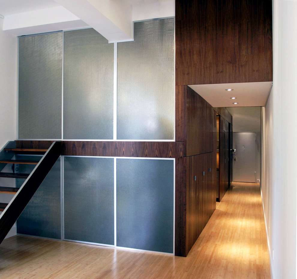 Imagen de recibidores y pasillos minimalistas de tamaño medio con paredes beige, suelo de madera clara y suelo beige